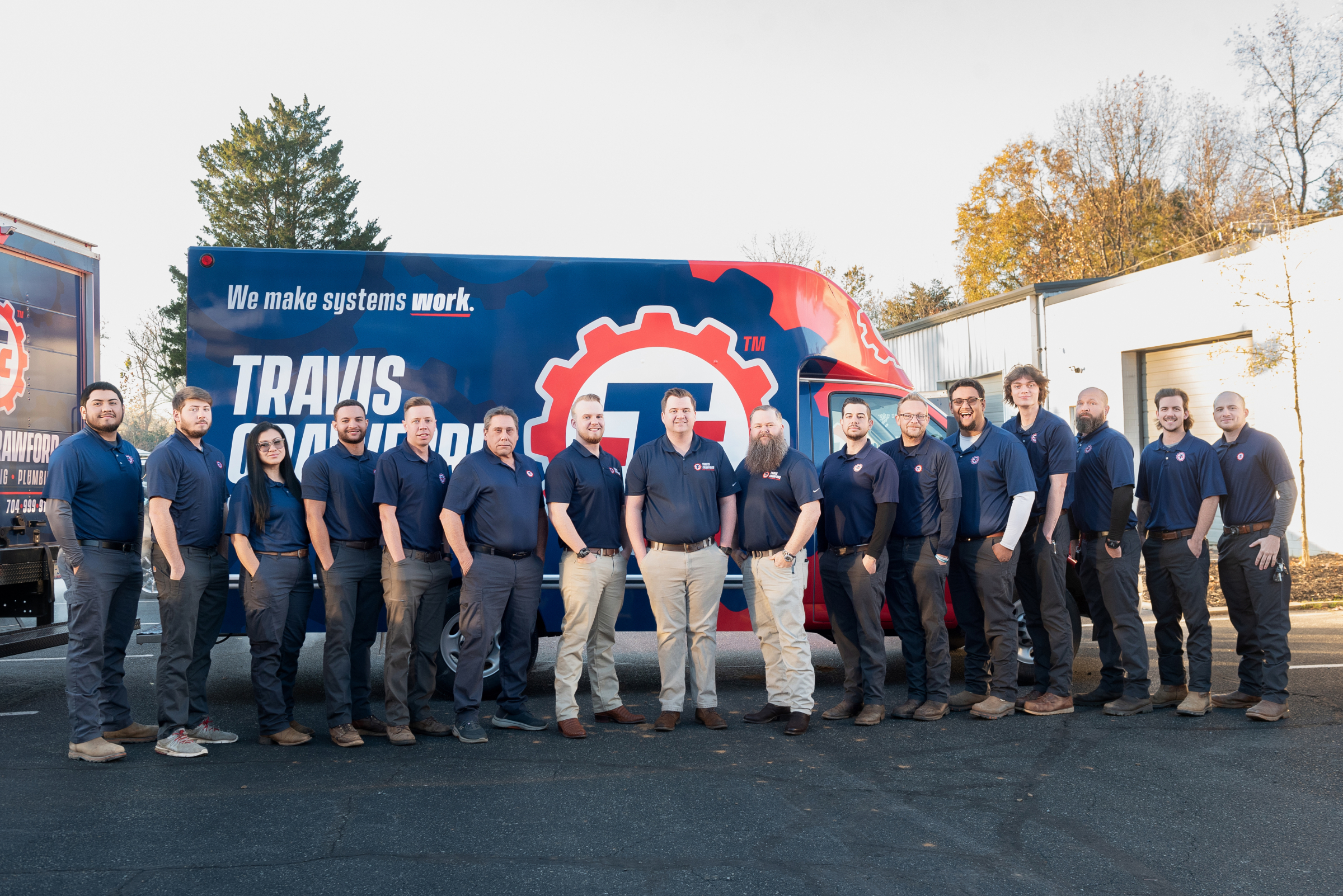 The Travis Crawford HVAC team poses in front of a branded vehicle in Charlotte, NC, ready to perform heating services